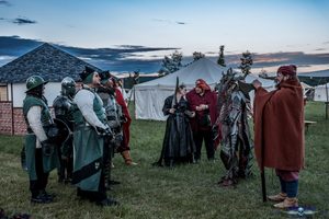 Die Elfe wird übergeben. Neben ihr in rot Chronist Skip und daneben wiederum eines der Drachenwesen aus der Stadt